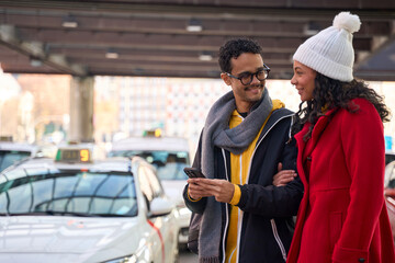 Young couple ordering taxi using mobile app in city