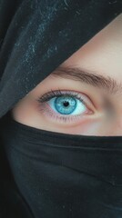 Fototapeta premium Intriguing Blue Eyes Hidden Behind a Black Hijab