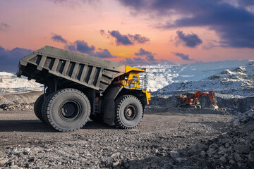 Obraz premium Coal mining, Open pit mine work in winter landscape with yellow dump truck and excavator