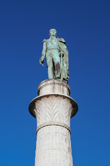 Statue of a historic figure on a tall column against a clear blue sky in Chambery France