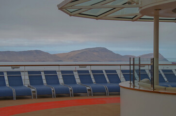 Outdoor deck patio terrace with lounge furniture and bar onboard luxury modern cruiseship cruise ship liner at sea