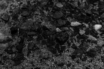 colorful sand and dark river water close-up