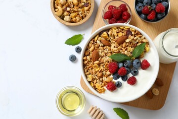 Delicious granola with berries and yogurt on a light background