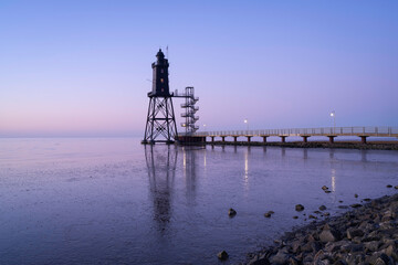 Lighthouse Obereversand at low tide with reflection.