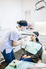 Fototapeta premium A woman is getting her teeth cleaned by a dentist