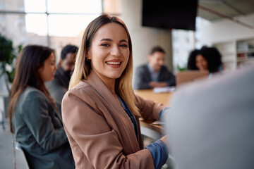 Obraz premium Happy businesswoman on meeting in office looking at camera.