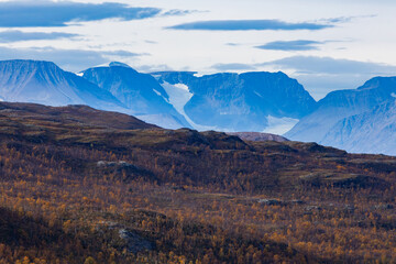 Autumn landscape of Kilpisjarvi, Finland, showcasing colorful foliage, serene lakes, and majestic mountains in the background.