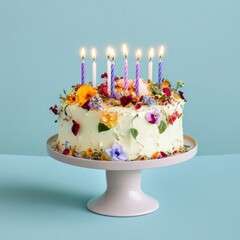 Floral Birthday Cake with Lit Candles on Pale Pink Stand