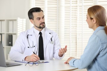Cardiologist consulting patient at table in clinic