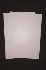 Mockup white sheets of paper on a dark brown background. Empty sheets of paper for your design.
