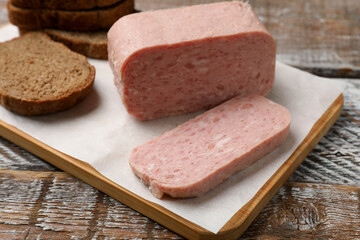 Canned meat and bread on wooden table, closeup