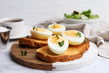 Sandwiches with hard boiled eggs on white marble table, closeup