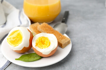 Soft boiled eggs with bread on grey table, closeup