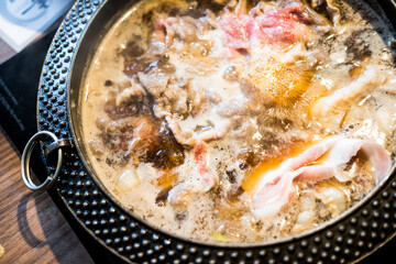 Boiled raw beef in hot sup sukiyaki. Japanese hot pot also known as Shabu Shabu or Sukiyaki is Japanese style.