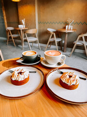 Coffee and dessert in a cozy cafe with wooden furniture at midday