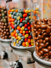 Colorful candy dispensers filled with vibrant treats in a sweet shop during the afternoon
