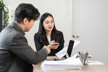 Business professionals discussing financial reports and strategies in a modern office setting.
