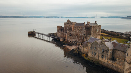 Fototapeta premium Historic castle on the Scottish coast overlooking calm waters at dawn
