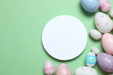 Happy Easter. Colorful eggs with white paper card on a pastel color background, space for text or advertising