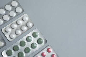 Pills in blister packs on gray  background, close up
