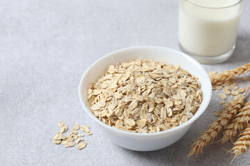 Composition with oatmeal flakes on gray background. Cooking breakfast