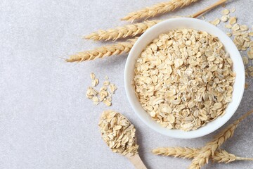Composition with oatmeal flakes on gray background. Cooking breakfast