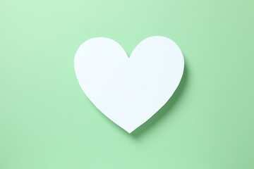 White paper heart on green background