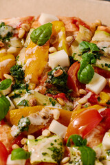 Vegetarian pinsa with tomatoes, peppers, nuts, basil and cheese