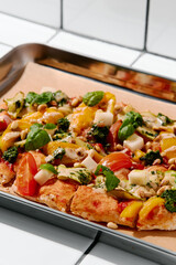 Vegetarian pinsa with tomatoes, peppers, nuts, basil and cheese