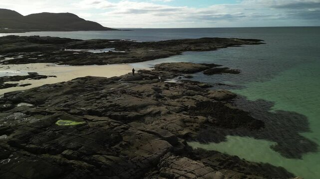 Aerial view of man standing on rocky coastline, Sanna Bay, Ardnamurchan, Scotland