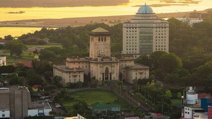 Golden sunrise city skyline overlooking part of busy crossroad with light trails and historical buildings in Johor Bahru, Malaysia. 