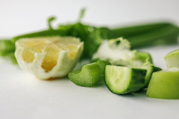 Fresh celery, cucumber, and lemon pieces on a white background. Healthy ingredients rich in vitamins and antioxidants for a balanced diet and natural detox
