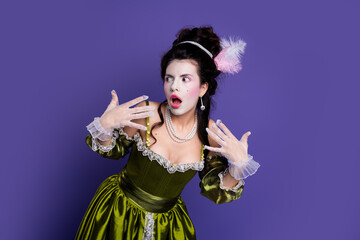 Naklejka premium Elegant young woman dressed as a historic aristocrat with green dress and pearls against a vibrant violet backdrop.