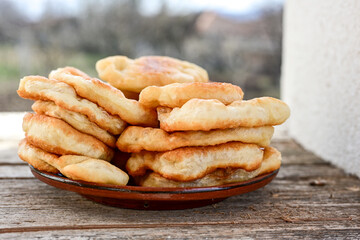 Traditional Bulgarian home made deep fried  patties  covered with sugar  оn rustic backgroud.Mekitsa or Mekica,  on wooden  rustic  background. Made of kneaded dough that is deep fried 