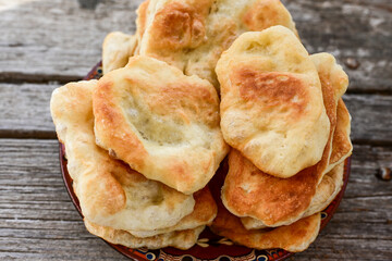 Traditional Bulgarian home made deep fried  patties  covered with sugar  оn rustic backgroud.Mekitsa or Mekica,  on wooden  rustic  background. Made of kneaded dough that is deep fried 