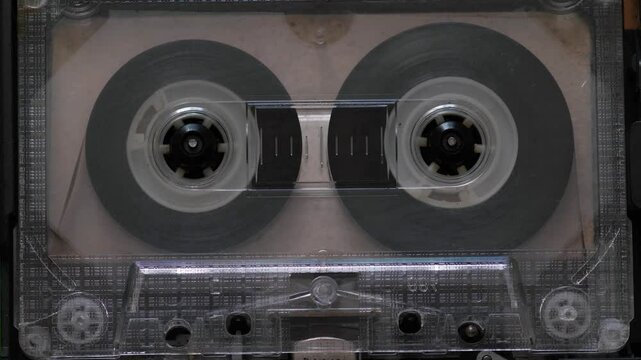 close up transparent audio cassette in cassette recorder playing music track, film cassette recorder with cassette tape macro