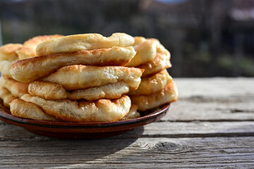 Traditional Bulgarian home made deep fried  patties  covered with sugar  оn rustic backgroud.Mekitsa or Mekica,  on wooden  rustic  background. Made of kneaded dough that is deep fried 