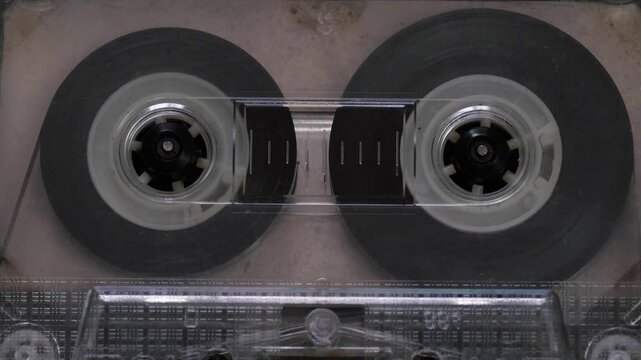 close up transparent audio cassette in cassette recorder playing music track, film cassette recorder with cassette tape macro