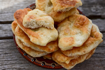 Traditional Bulgarian home made deep fried  patties  covered with sugar  оn rustic backgroud.Mekitsa or Mekica,  on wooden  rustic  background. Made of kneaded dough that is deep fried 