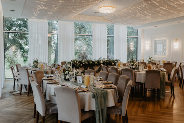 An elegantly decorated banquet table set for a formal event with luxurious gold-rimmed plates, fine dining silverware, crystal glassware