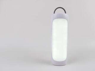 A simple portable emergency light is on - isolated on white