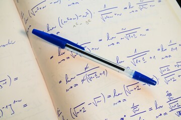 Fototapeta premium Notebook with Mathematical Equations and Blue Pen