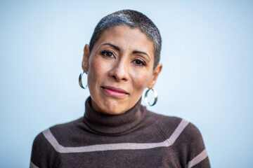 Portrait of a thoughtful woman in striped turtleneck with hoop earrings