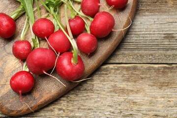Many fresh radishes on wooden table, top view. Space for text