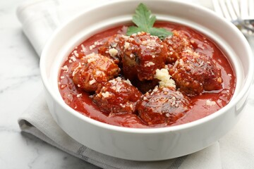 Delicious meatballs with tomato sauce, parmesan cheese and parsley on table, closeup