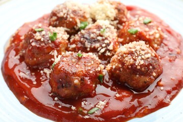 Delicious meatballs with tomato sauce, parmesan and herbs in bowl, closeup