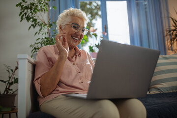 Elderly lady using her laptop and smiling