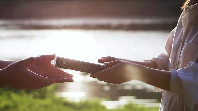 Christian giving the Holy Bible as a gift, church evangelism concept that spreads the gospel and love of Jesus Christ
