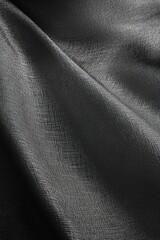 Fototapeta premium Close-up of dark gray fabric with subtle texture and folds.