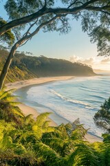 Obraz premium Serene sunrise over secluded, crescent beach framed by lush foliage.